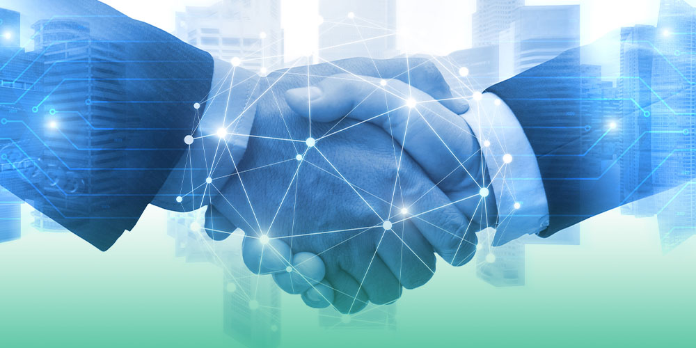 Dois homens brancos, com roupas formais, apertam as mãos. A imagem tem um filtro azul, com símbolos que representam a tecnologia. A imagem representa duas pessoas fechando negócios no meio digital.